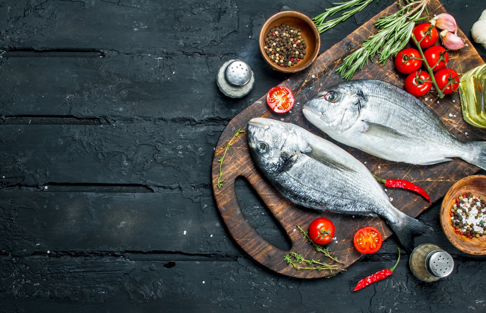 Raw sea fish dorado with spices and rosemary.