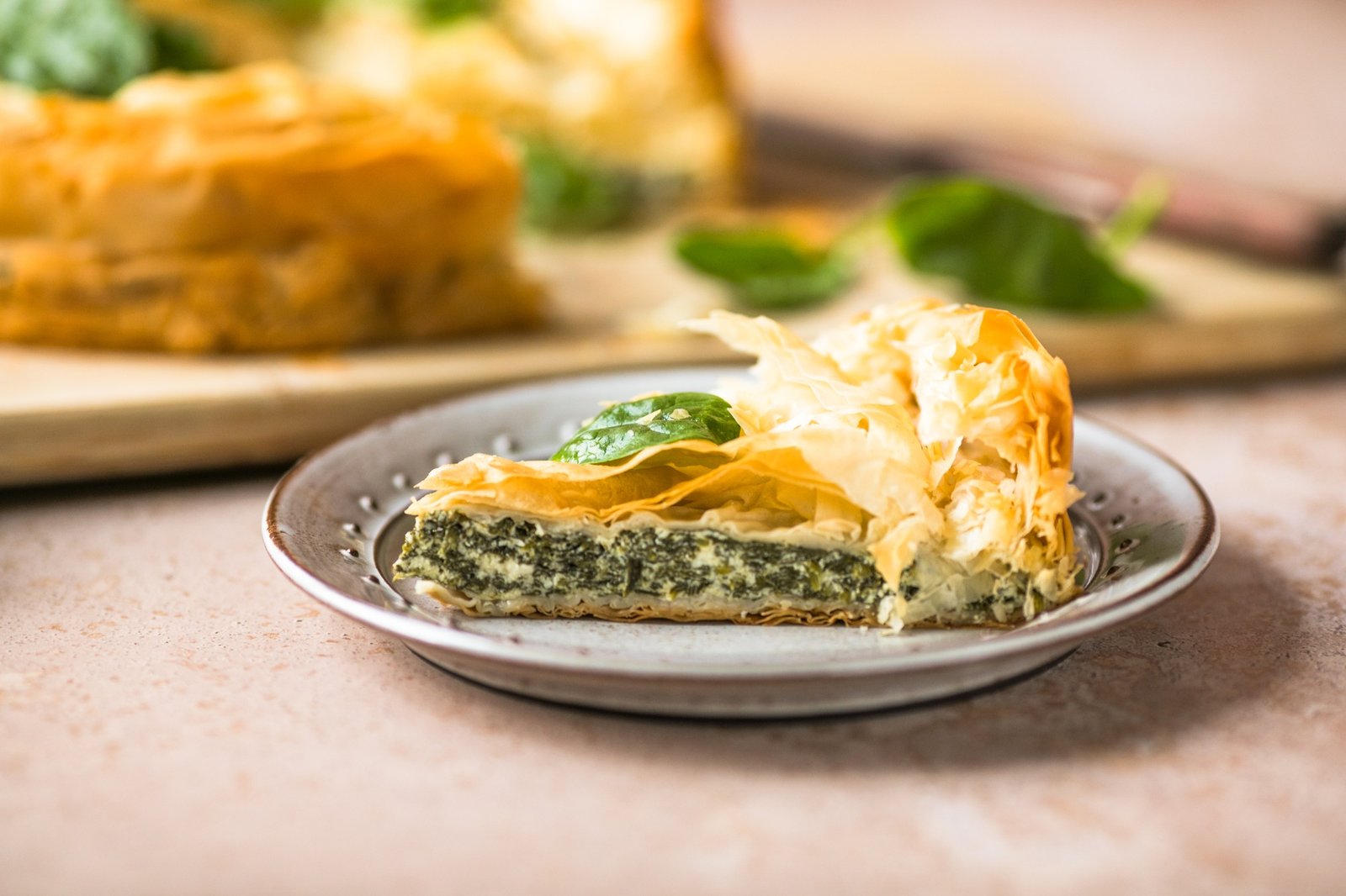 Spanakopita Greek Pie with Spinach and Cheese on wooden board. Dark background. Top view