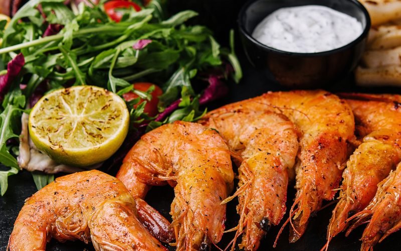 Traditional greek grilled seafood on restaurant wooden plate